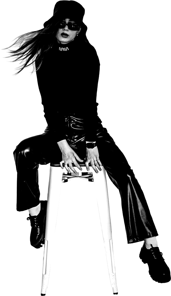 Editorial fashion model in a bucket hat, black turtleneck and leather trousers seated on a stool — Insider Edits luxury archive collections
